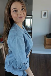 Portrait of smiling young woman standing at home