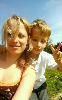 Close-up portrait of smiling girl against sky