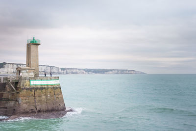 View of sea and buildings against sky. view of sea and lighthouse against sky 