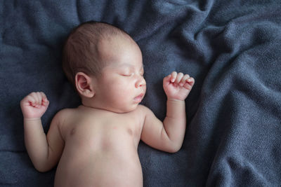 High angle view of baby lying on bed