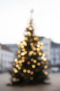 Defocused image of illuminated christmas tree against sky