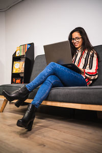 Full length of woman using laptop while sitting at office