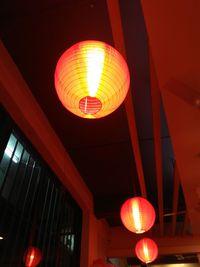 Low angle view of illuminated lanterns hanging in city at night