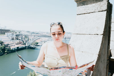 Portrait of young woman standing against wall