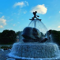 Low angle view of water splashing against sky