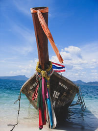 Traditional windmill on beach against sky