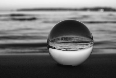 Close-up of crystal ball on beach