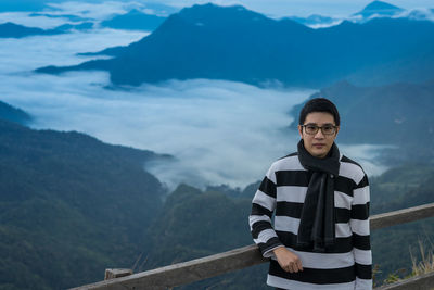 Portrait of young man standing on mountain