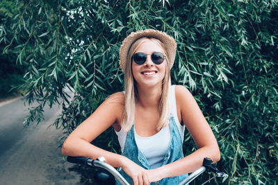 Portrait of smiling teenage girl with bicycle