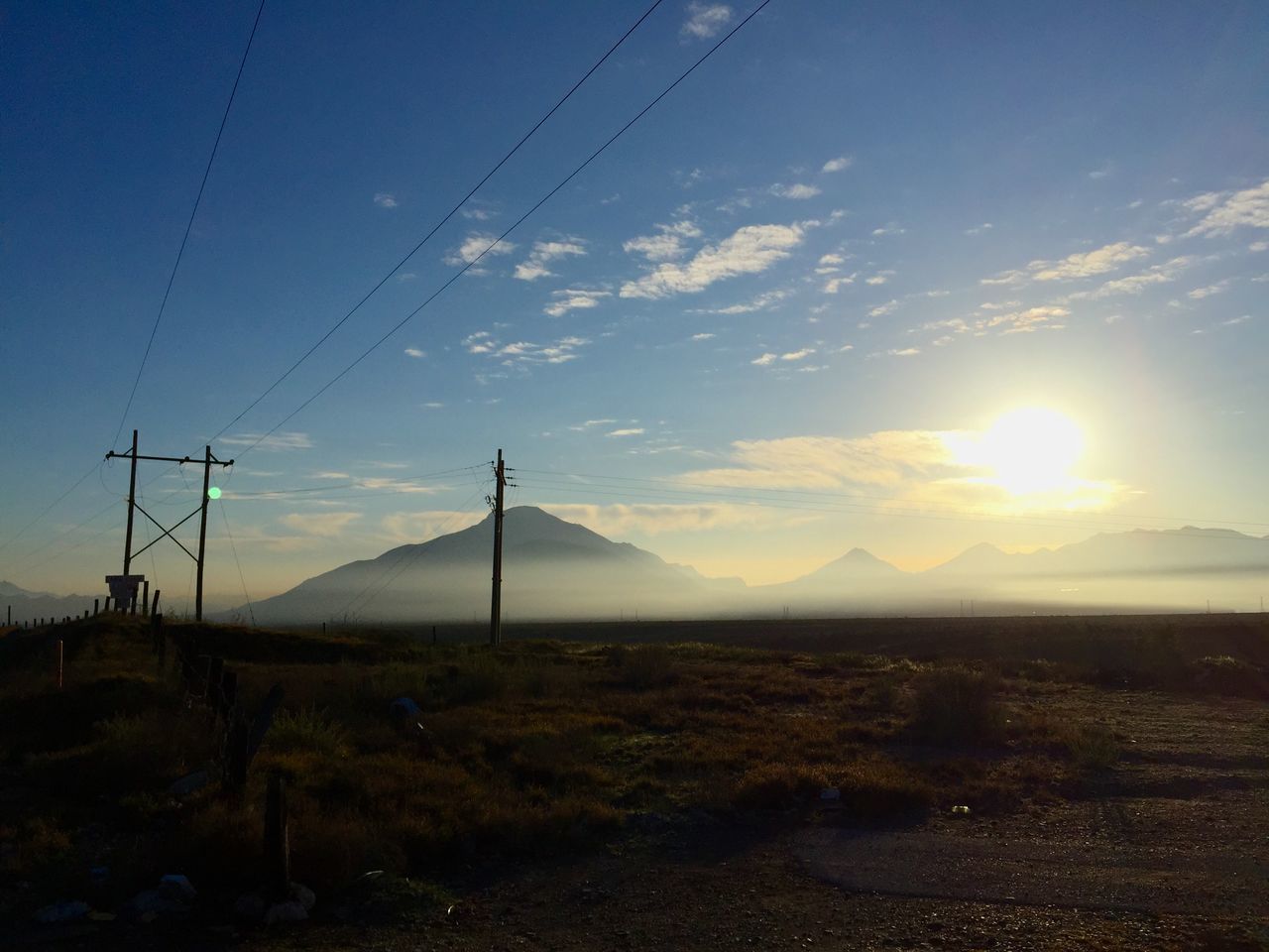 landscape, electricity pylon, fuel and power generation, tranquility, tranquil scene, scenics, power line, electricity, sky, sun, mountain, beauty in nature, sunset, power supply, nature, connection, field, mountain range, technology, non-urban scene