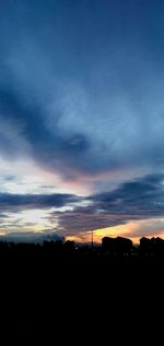Silhouette landscape against dramatic sky during sunset