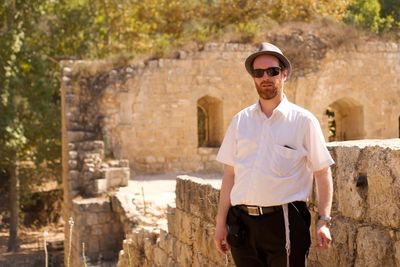Portrait of young man wearing sunglasses standing outdoors
