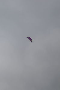 Low angle view of person paragliding against sky