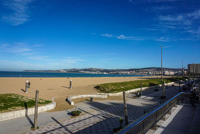 High angle view of footpath by sea against blue sky