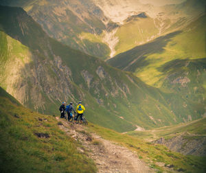 Rear view of people walking on mountain road