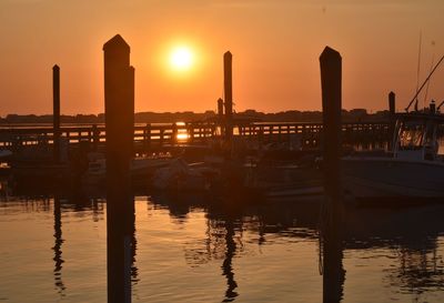 Reflection of silhouette buildings in water at sunset