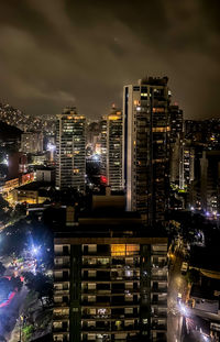 Illuminated cityscape against sky at night