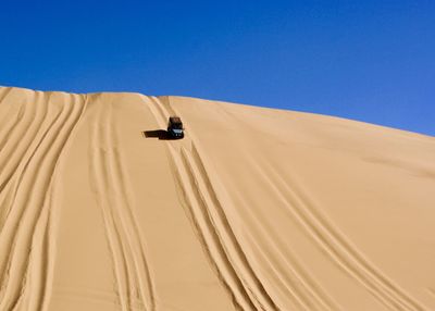 Scenic view of desert against clear blue sky