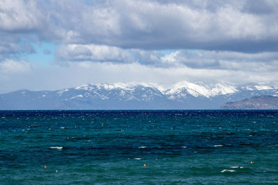 Scenic view of sea and mountains against sky
