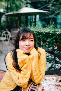 Portrait of smiling woman sitting outdoors