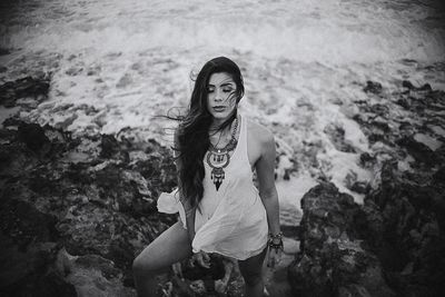 Portrait of young woman standing at beach