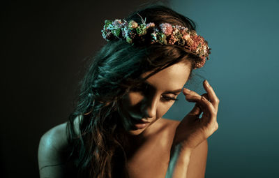 Portrait of young woman looking away against gray background