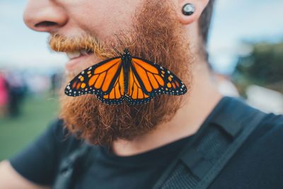 Midsection of man with butterfly on beard