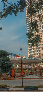 Road by buildings against sky in city