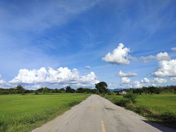 Road amidst field against sky