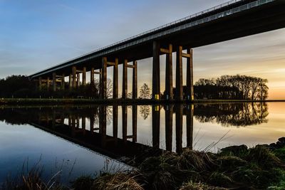 View of bridge over lake against cloudy sky