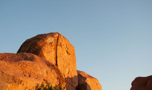 Low angle view of rock formation against clear blue sky