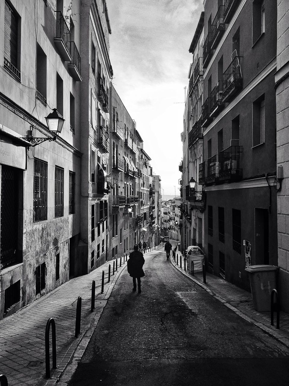 building exterior, architecture, built structure, the way forward, street, walking, men, city, residential building, residential structure, person, rear view, building, diminishing perspective, city life, lifestyles, sky, transportation