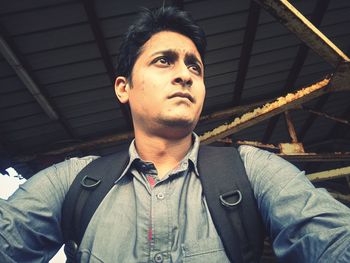 Low angle view of young man under shed