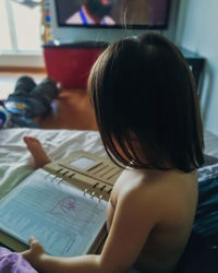 Side view of girl with book at home