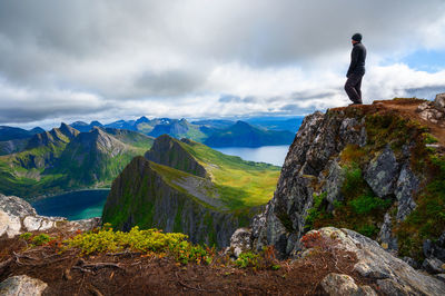 Rear view of man walking on mountain against sky