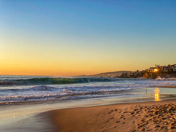 Sunset reflecting off window at beach with surf waves on beach in laguna beach, california