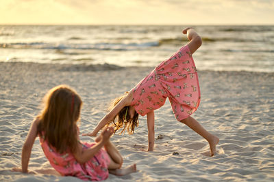 Two sisters playing on the beach at the day time. concept of friendly sister.