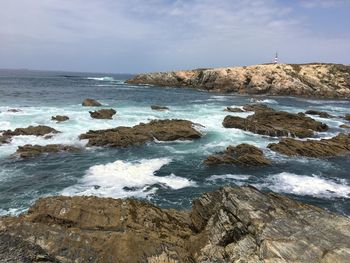 Rocks in sea against sky