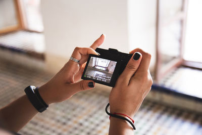 Cropped hands of woman photographing with camera