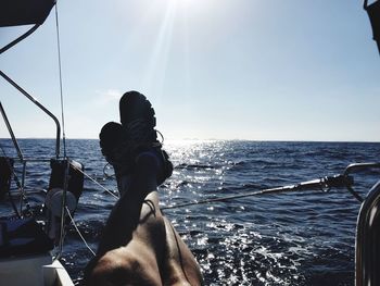 Friends on sea against sky on sunny day