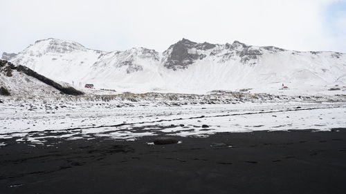 Scenic view of snowcapped mountains by sea against sky