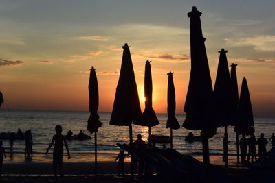 Silhouette people on beach during sunset