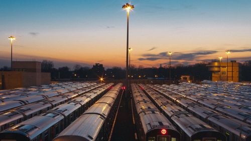 Illuminated city against sky at sunset