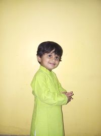 Portrait of boy standing against wall