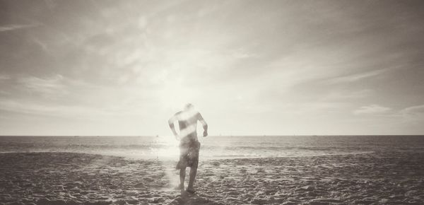 Man with dog on beach against sky