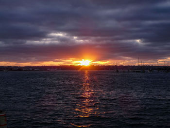 Scenic view of sea against dramatic sky during sunset