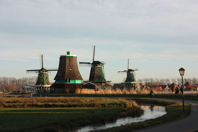 Traditional windmill on field against sky