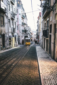 Railroad tracks in city against sky