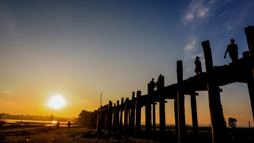 Silhouette bridge against sky during sunset