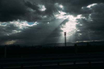 Low angle view of smoke stack against cloudy sky